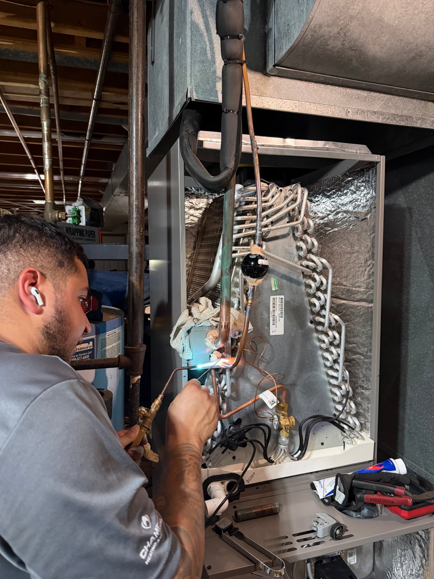 Alvizo Heating & Cooling technician brazing a copper refrigerant line on an evaporator coil